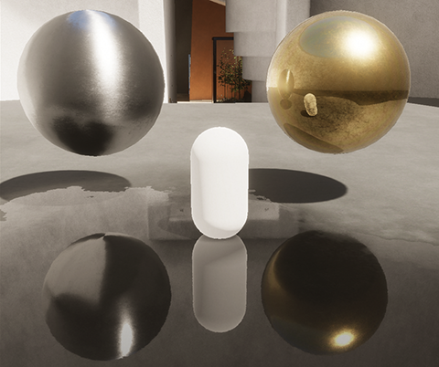 A bright white capsule, with a reflective silver metallic sphere on the left and a reflective gold metallic sphere on the right. The capsule is visible in the reflection on the surface of the gold sphere.