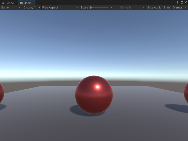 An image of the Game view. It displays one red metallic sphere and the edges of a sphere on either side of the middle sphere.